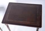 Mesa ninho de madeira nobre com tampos de couro... - Mesa ninho de madeira nobre com tampos de couro pirogravado, composto de 3 peças, pernas cilíndrica frisadas. Com desgastes.