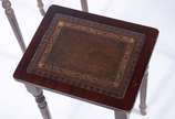 Mesa ninho de madeira nobre com tampos de couro... - Mesa ninho de madeira nobre com tampos de couro pirogravado, composto de 3 peças, pernas cilíndrica frisadas. Com desgastes.