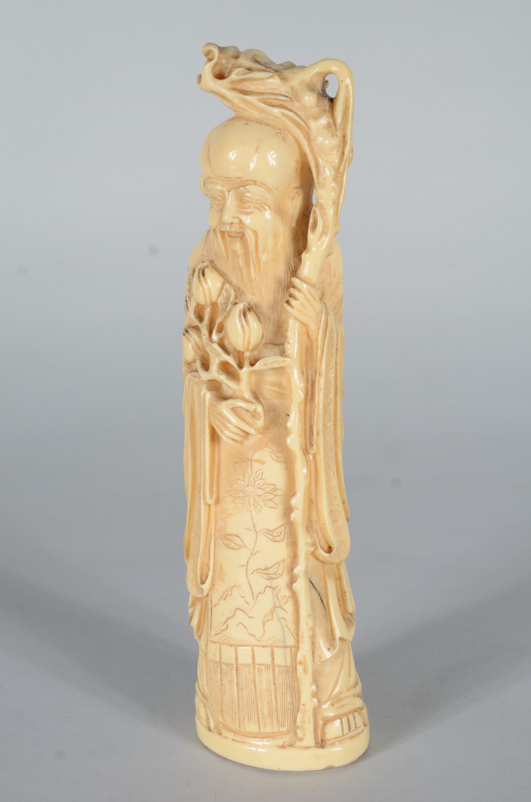 Escultura de marfim representando sábio com cajado e frutos. - foto 2 de 6