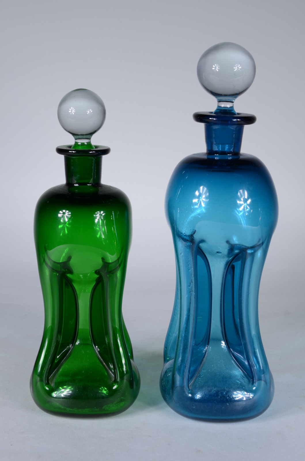 Duas garrafas de vidro sendo uma verde e outra azul. - foto 1 de 6