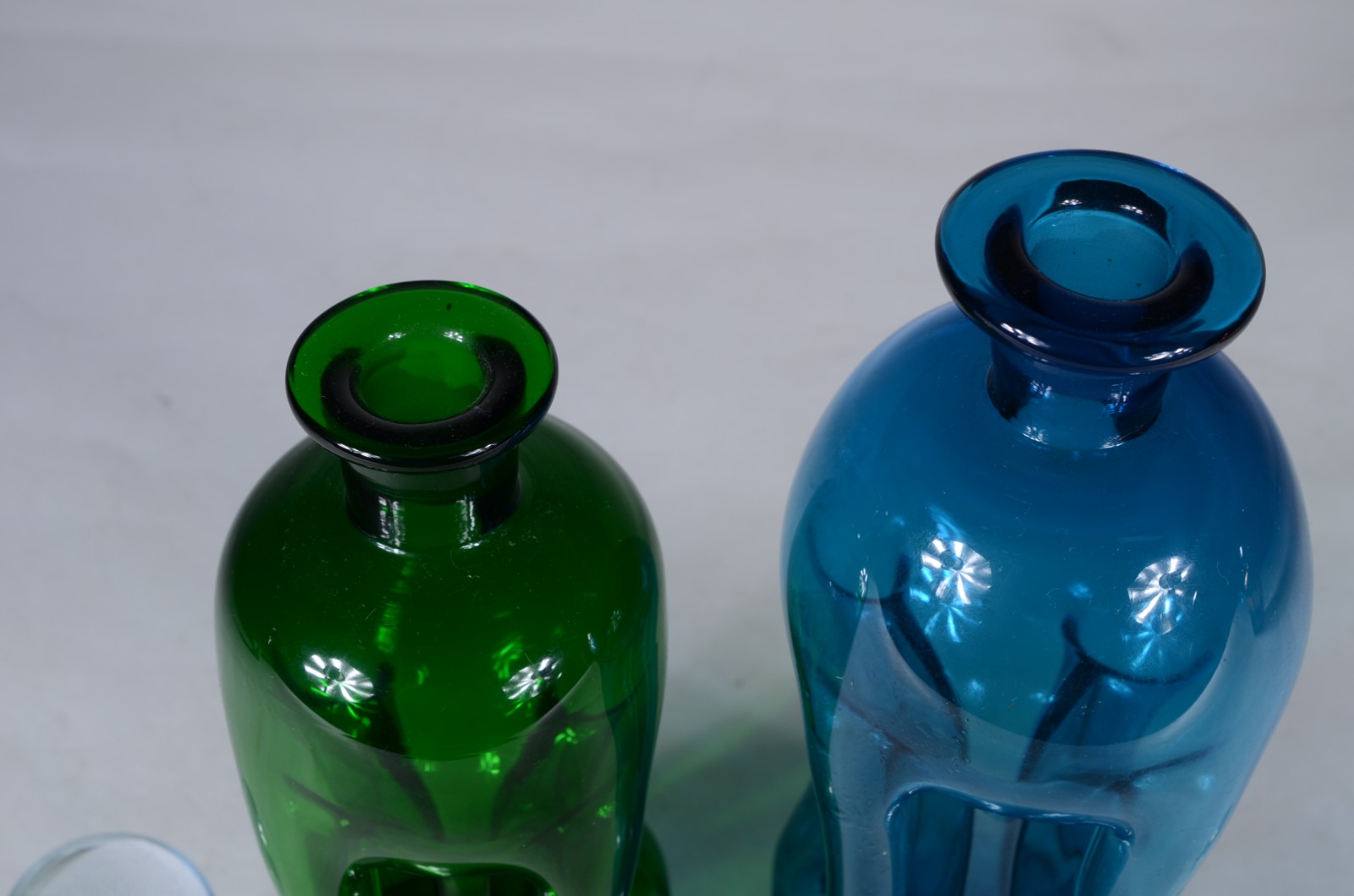 Duas garrafas de vidro sendo uma verde e outra azul. - foto 3 de 6