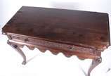 Mesa de madeira nobre com gavetão entalhado, sa... - Mesa de madeira nobre com gavetão entalhado, saia recortada e pernas ligeiramente recurvas (folheado do tampo descascando).