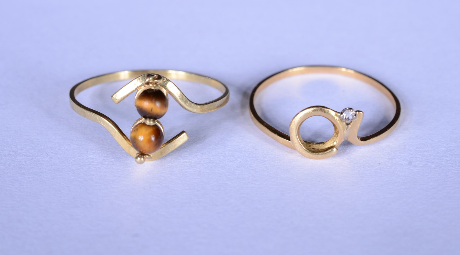 Dois anéis de ouro 18 k., sendo um com olho de tigre e outro com... - foto 1 de 8