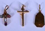 Três pendentes de ouro 18 k., sendo: 2 crucifix... - Três pendentes de ouro 18 k., sendo: 2 crucifixos sendo um deles com pedra colorida e medalha. (Por motivos de segurança a peça não se encontra ...