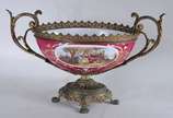 Fruteira de porcelana francesa com paisagem e c... - Fruteira de porcelana francesa com paisagem e cena romântica em policromia, sobre fundo rosa. Guarnição de metal dourado.