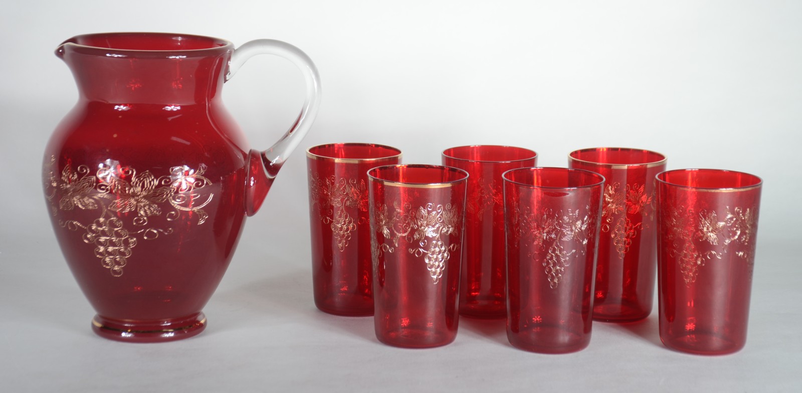 Conjunto com jarra e 6 copos de vidro vermelho decorados com cachos... - foto 2 de 9