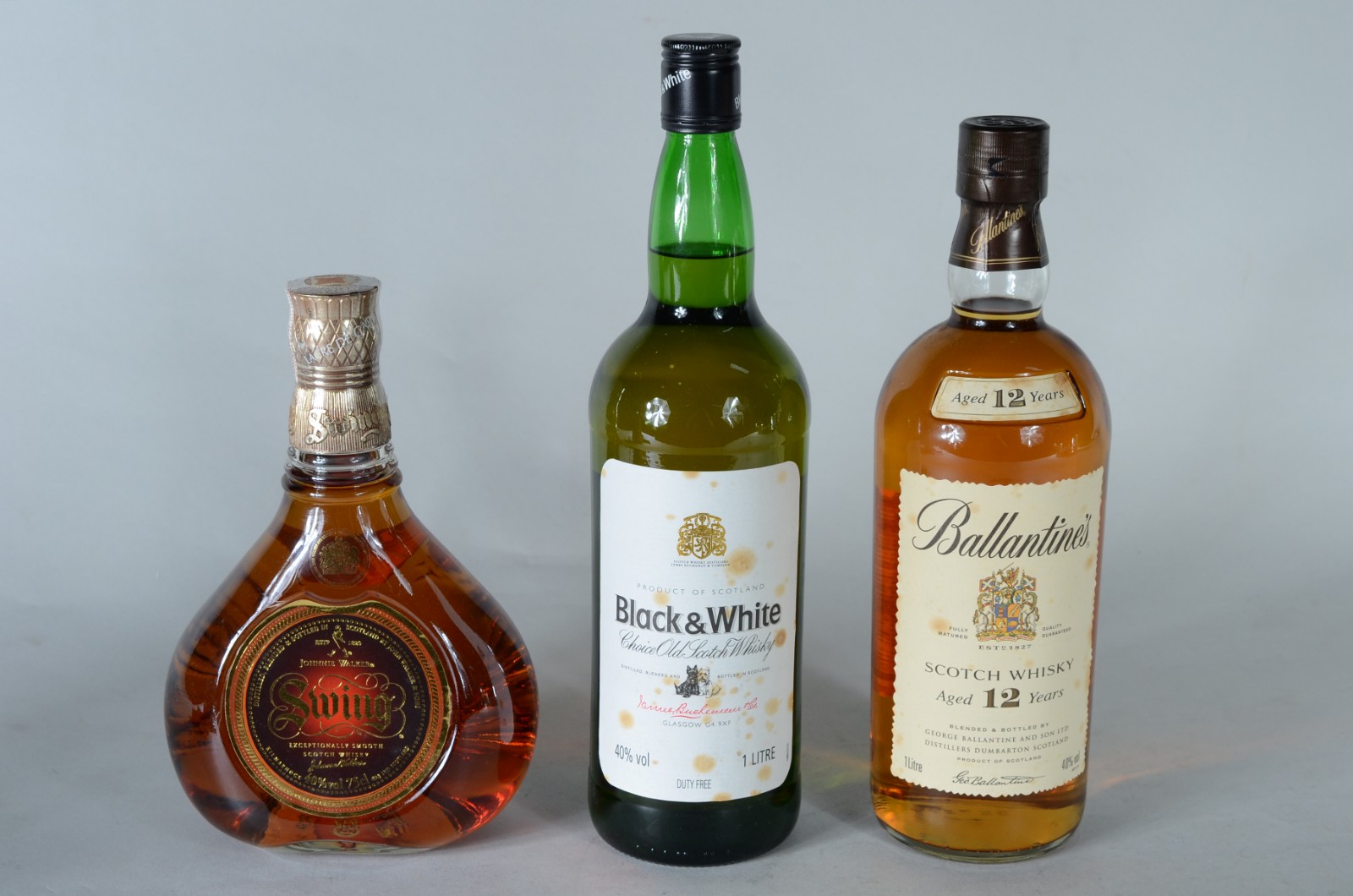 Três garrafas de whisky diversos, sendo: Johnnie Walker Swing... - foto 1 de 8