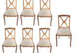 Conjunto com 7 cadeiras de madeira clara para s... - Conjunto com 7 cadeiras de madeira clara para sala de jantar, encostos com traves na forma de "X", assentos estofados. Algumas delas com pequeno...