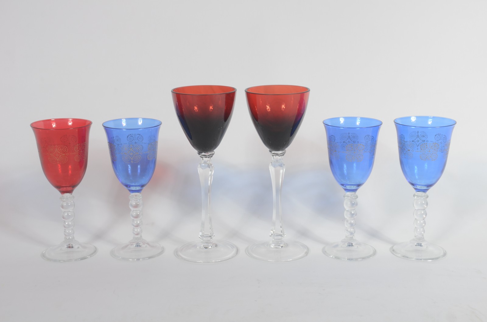 Quatro cálices de cristal para vinho branco, sendo um vermelho e 3... - foto 1 de 5