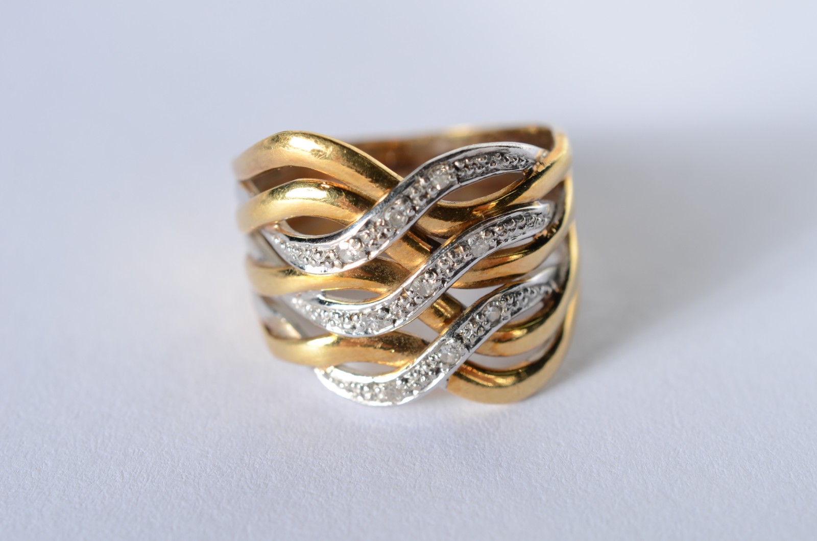 Anel de ouro 18 k., contraste 750 mls, entrelaçado e cravejado com... - foto 1 de 6