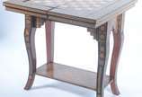 Mesa de jogo marroquina de madeira com incrusta... - Mesa de jogo marroquina de madeira com incrustações, tampo dobrável com tabuleiros para gamão, damas/xadrez e cartas. Desgastes.