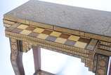 Mesa de jogo marroquina de madeira com incrusta... - Mesa de jogo marroquina de madeira com incrustações, tampo dobrável com tabuleiros para gamão, damas/xadrez e cartas. Desgastes.