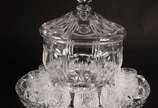 Conjunto de poncheira de cristal lapidado com 1... - Conjunto de poncheira de cristal lapidado com 11 taças (outra lapidação) e presentoir. Poncheira com mínimos bicados.