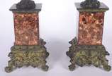 Quatro peças decorativas: sendo um par de cande... - Quatro peças decorativas: sendo um par de candelabros de metal dourado com figuras de "pucci" (um colado); e, par de colunas com figuras mitológ...