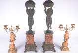 Quatro peças decorativas: sendo um par de cande... - Quatro peças decorativas: sendo um par de candelabros de metal dourado com figuras de "pucci" (um colado); e, par de colunas com figuras mitológ...