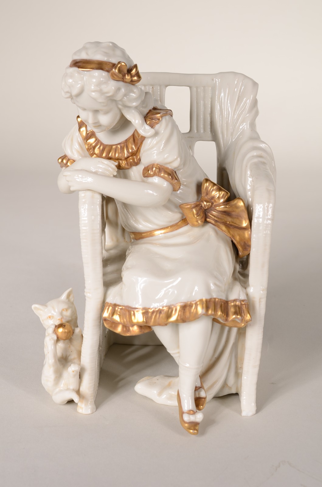 Grupo escultórico de porcelana representando menina sentada com gato. - foto 1 de 9