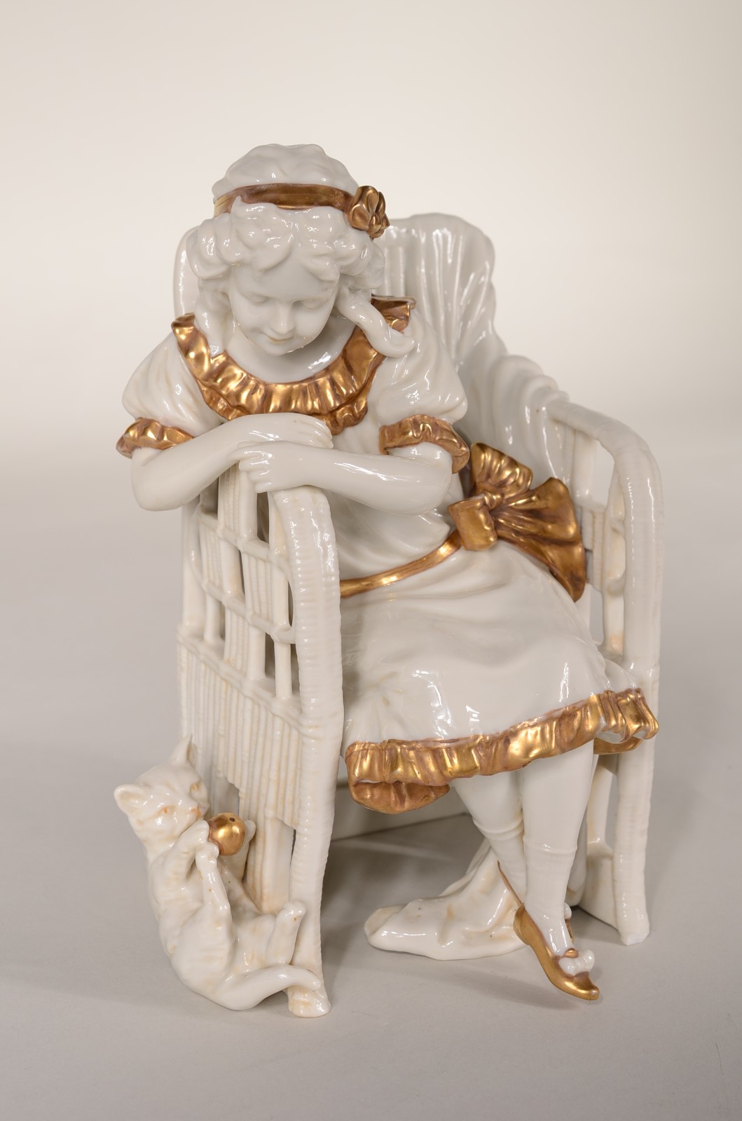 Grupo escultórico de porcelana representando menina sentada com gato. - foto 2 de 9