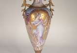 Ânfora Art Nouveau de porcelana europeia decora... - Ânfora Art Nouveau de porcelana europeia decorada com figura feminina e guirlandas florais em policromia e realces dourados, guarnição de bronze.