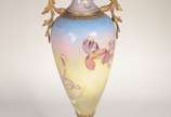 Ânfora Art Nouveau de porcelana europeia decora... - Ânfora Art Nouveau de porcelana europeia decorada com figura feminina e guirlandas florais em policromia e realces dourados, guarnição de bronze.