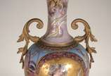 Ânfora Art Nouveau de porcelana europeia decora... - Ânfora Art Nouveau de porcelana europeia decorada com figura feminina e guirlandas florais em policromia e realces dourados, guarnição de bronze.
