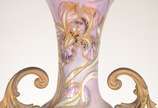 Ânfora Art Nouveau de porcelana europeia decora... - Ânfora Art Nouveau de porcelana europeia decorada com figura feminina e guirlandas florais em policromia e realces dourados, guarnição de bronze.