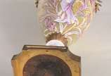 Ânfora Art Nouveau de porcelana europeia decora... - Ânfora Art Nouveau de porcelana europeia decorada com figura feminina e guirlandas florais em policromia e realces dourados, guarnição de bronze.
