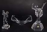 Três peças de cristal, sendo: 2 esculturas repr... - Três peças de cristal, sendo: 2 esculturas representando bailarina e jogador de golf e, pequena fruteira retangular.