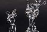 Três peças de cristal, sendo: 2 esculturas repr... - Três peças de cristal, sendo: 2 esculturas representando bailarina e jogador de golf e, pequena fruteira retangular.