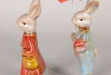 Duas esculturas de porcelana policromada repres... - Duas esculturas de porcelana policromada representando casal de coelhos.