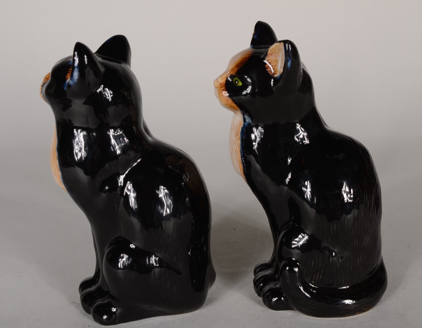 Duas esculturas de porcelana policromada representando gatos sentados. - foto 4 de 6