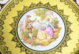 Par de medalhões de porcelana "Dom Pedro" decor... - Par de medalhões de porcelana "Dom Pedro" decorados com cenas românticas em policromia sobre fundo amarelo e guirlandas douradas.