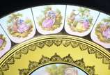 Par de medalhões de porcelana "Dom Pedro" decor... - Par de medalhões de porcelana "Dom Pedro" decorados com cenas românticas em policromia sobre fundo amarelo e guirlandas douradas.