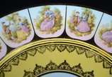 Par de medalhões de porcelana "Dom Pedro" decor... - Par de medalhões de porcelana "Dom Pedro" decorados com cenas românticas em policromia sobre fundo amarelo e guirlandas douradas.