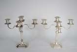 Par de candelabros de prata contraste 800 mls. ... - Par de candelabros de prata contraste 800 mls. para 5 velas cada, base oitavada. Peso da prata: 1350 g. Uma das hastes esta quebrada. (Por motiv...