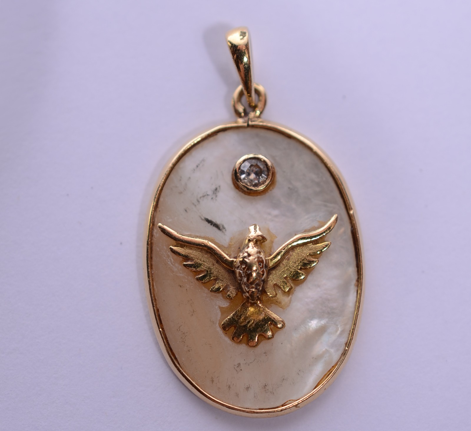 Pendente feitio oval de ouro 18 k., diamante e pomba da paz. (Por... - foto 1 de 4