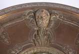 Centro de mesa/fruteira de bronze, base decorad... - Centro de mesa/fruteira de bronze, base decorada com figuras de "Pucci" sustentando o prato trabalhado com rostos e folhagens rem relevo.