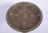 Centro de mesa/fruteira de bronze, base decorad... - Centro de mesa/fruteira de bronze, base decorada com figuras de "Pucci" sustentando o prato trabalhado com rostos e folhagens rem relevo.