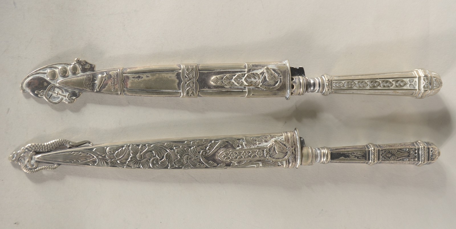 Duas facas com bainhas trabalhadas de metal prateado. - foto 1 de 11