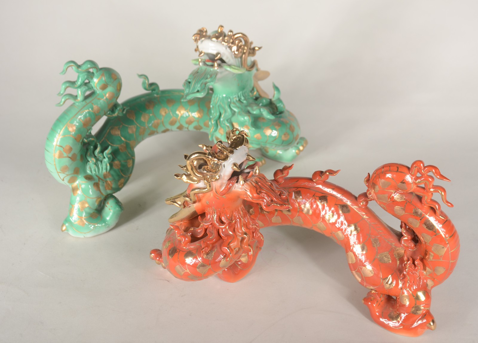 Dois dragões de porcelana oriental, sendo uma laranja e outro verde... - foto 1 de 10