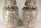 Par de vasos de porcelana oriental decorados co... - Par de vasos de porcelana oriental decorados com figuras de gueixas e sábios em policromia, realces dourados, pegas na forma de cães de Fó. Um d...