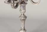 Christofle (1830),  - Candelabro de metal prateado para quatro velas, base feitio oitavado, trabalhado com guirlandas e figuras estilizadas em relevo. Com amassados.
