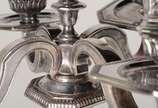 Christofle (1830),  - Candelabro de metal prateado para quatro velas, base feitio oitavado, trabalhado com guirlandas e figuras estilizadas em relevo. Com amassados.