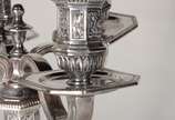 Christofle (1830),  - Candelabro de metal prateado para quatro velas, base feitio oitavado, trabalhado com guirlandas e figuras estilizadas em relevo. Com amassados.
