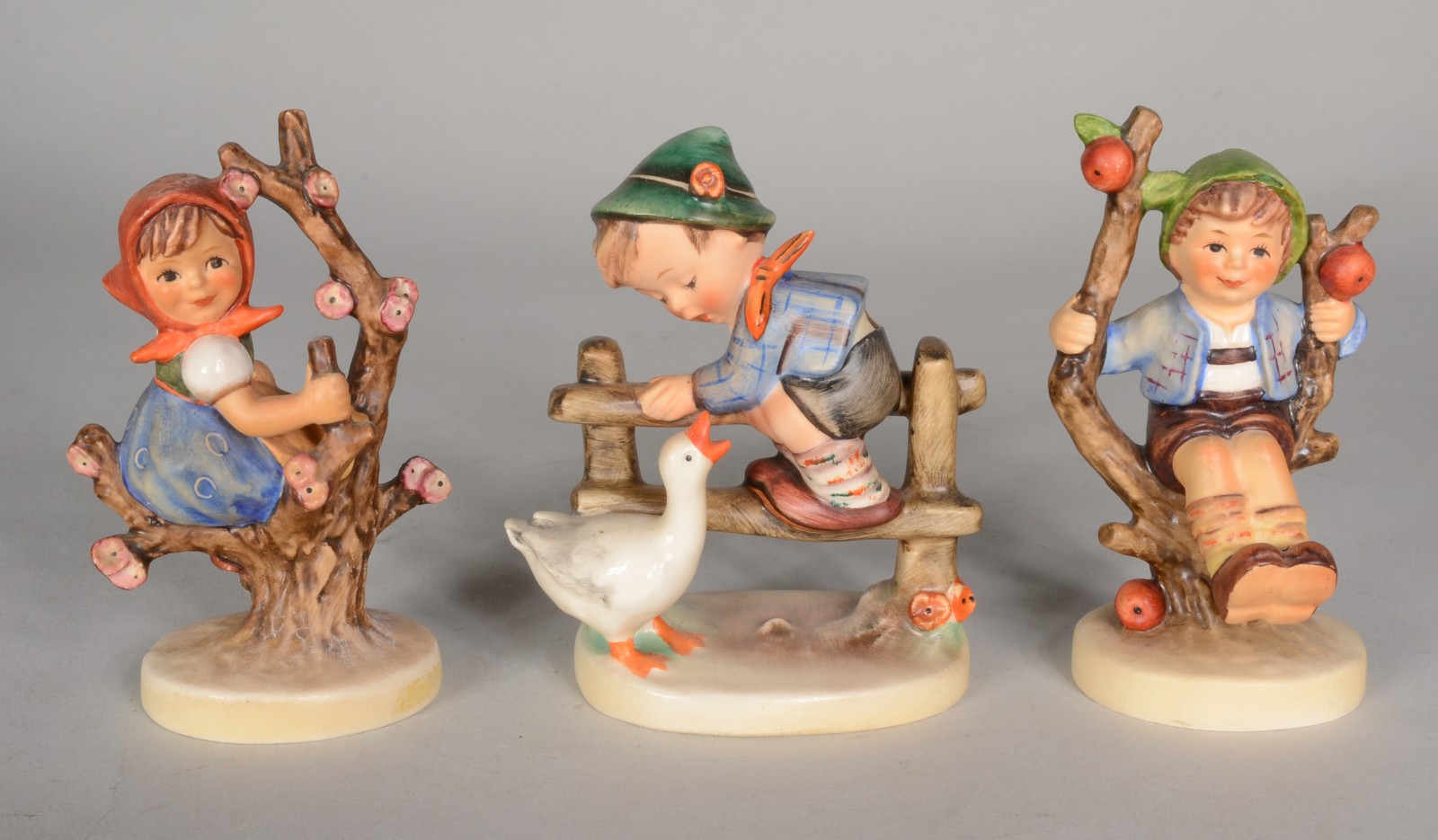 Três estatuetas de porcelana alemã Goebel, representando crianças... - foto 1 de 11