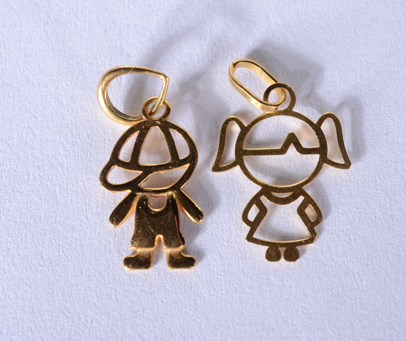 Dois pendentes feitio menina e menino de ouro 18 k., contraste 750... - foto 1 de 4