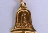 Pendente na forma de Sino com Nossa Senhora Apa... - Pendente na forma de Sino com Nossa Senhora Aparecida de ouro 18 k., contraste 750 mls. (Por motivos de segurança a peça não se encontra na loja).