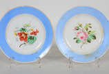 Dois pratos decorativos de porcelana com flores... - Dois pratos decorativos de porcelana com flores em policromia e  bordas na cor azul 