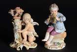 Meissen (1708),  - Duas esculturas de porcelana alemã, sendo uma representando anjo na fonte e outro representando menino segurando guirlanda, marcadas na base.