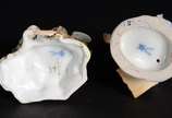 Meissen (1708),  - Duas esculturas de porcelana alemã, sendo uma representando anjo na fonte e outro representando menino segurando guirlanda, marcadas na base.