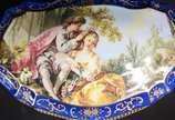 Caixa/porta jóias de porcelana francesa, decora... - Caixa/porta jóias de porcelana francesa, decorada com cena galante em policromia sobre fundo azul e guirlandas douradas, parte interna com flore...